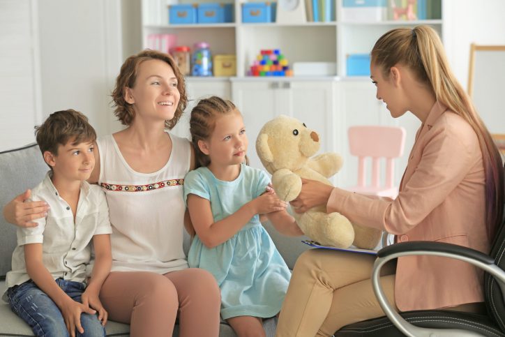 Young child psychologist working with family in office